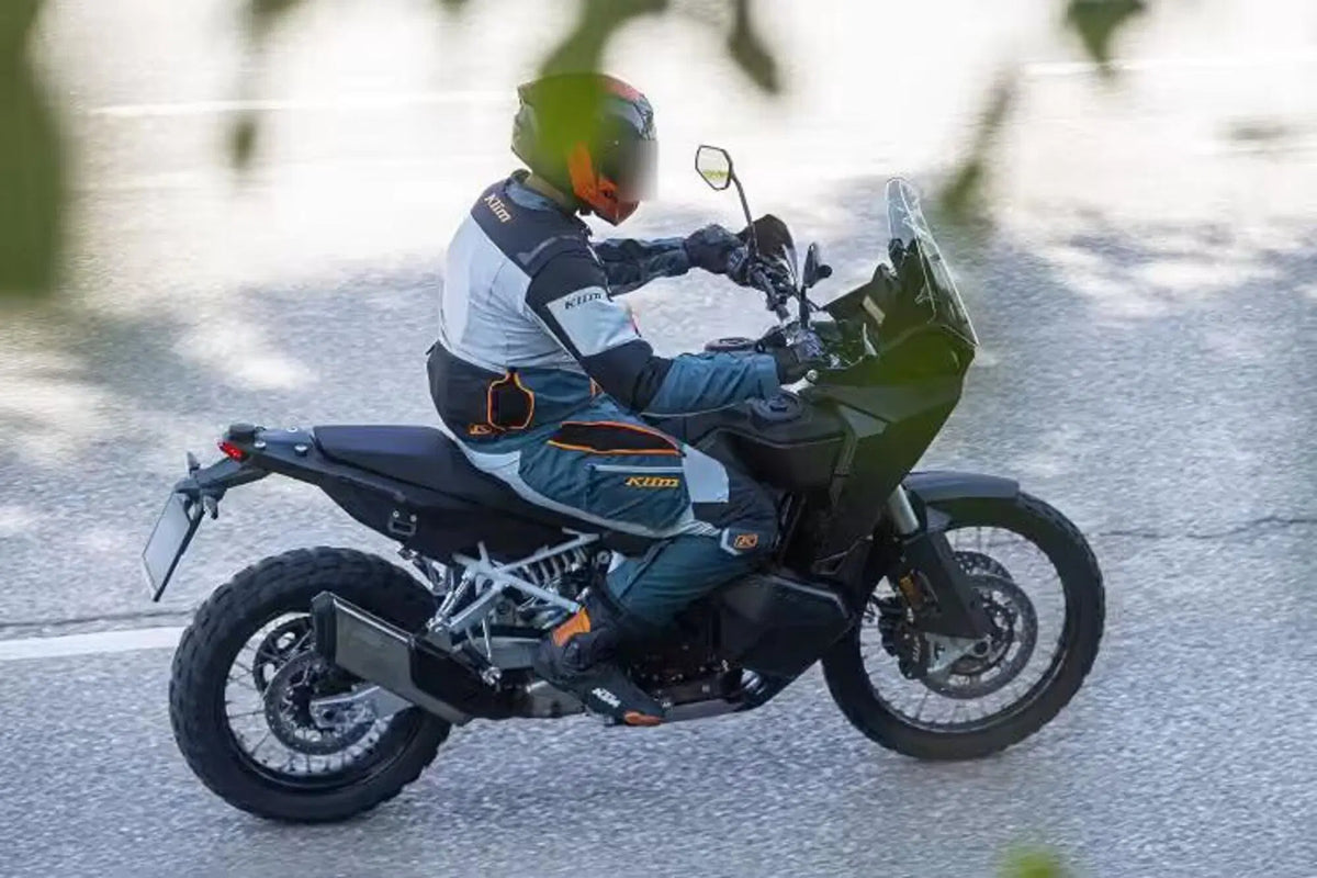 Prototipo della KTM 990 Adventure in curva, vista di tre quarti anteriore con faro e cupolino