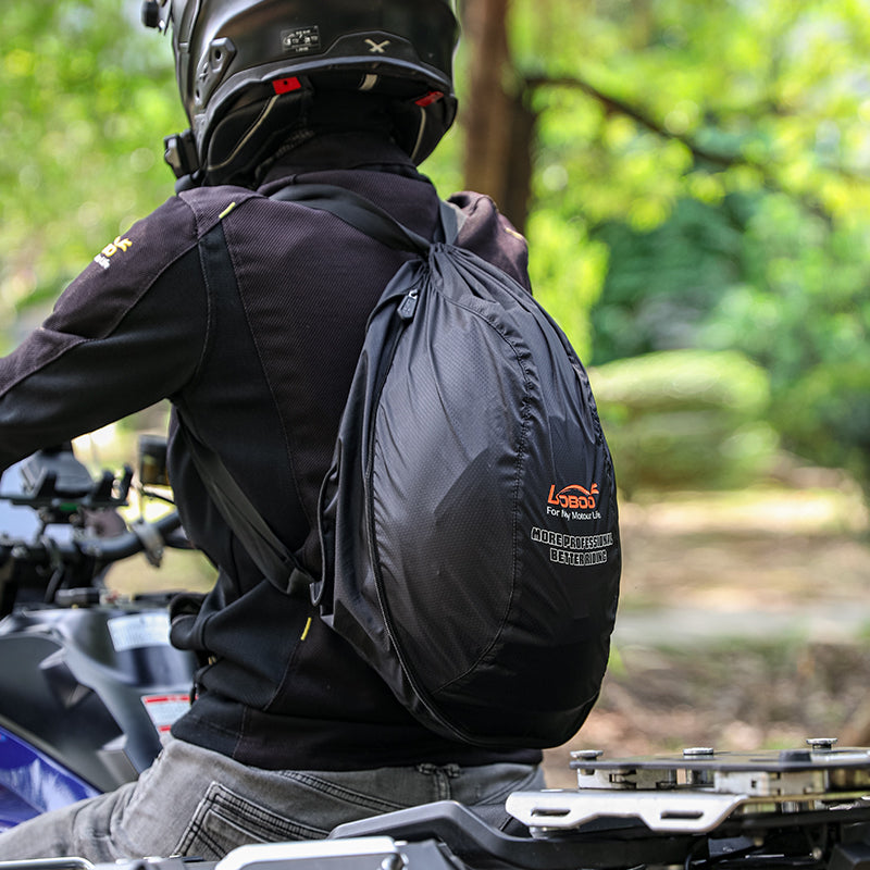 Motociclista con la borsa porta casco LOBOO BHB01BK indossata a zaino, vista da dietro