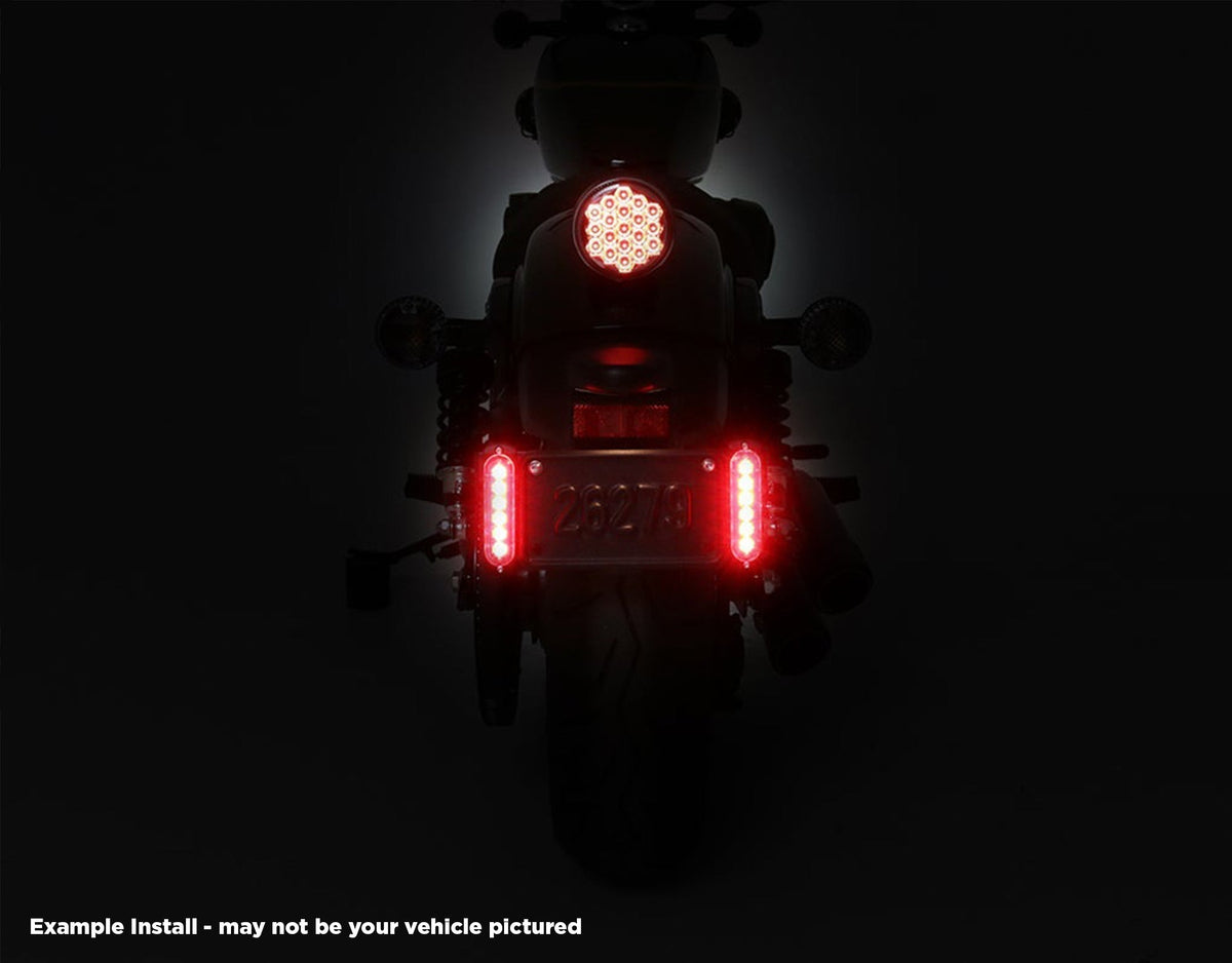 Doppia luce freno B6 DENALI accesa ai lati della targa sulla Honda Africa Twin, vista notturna