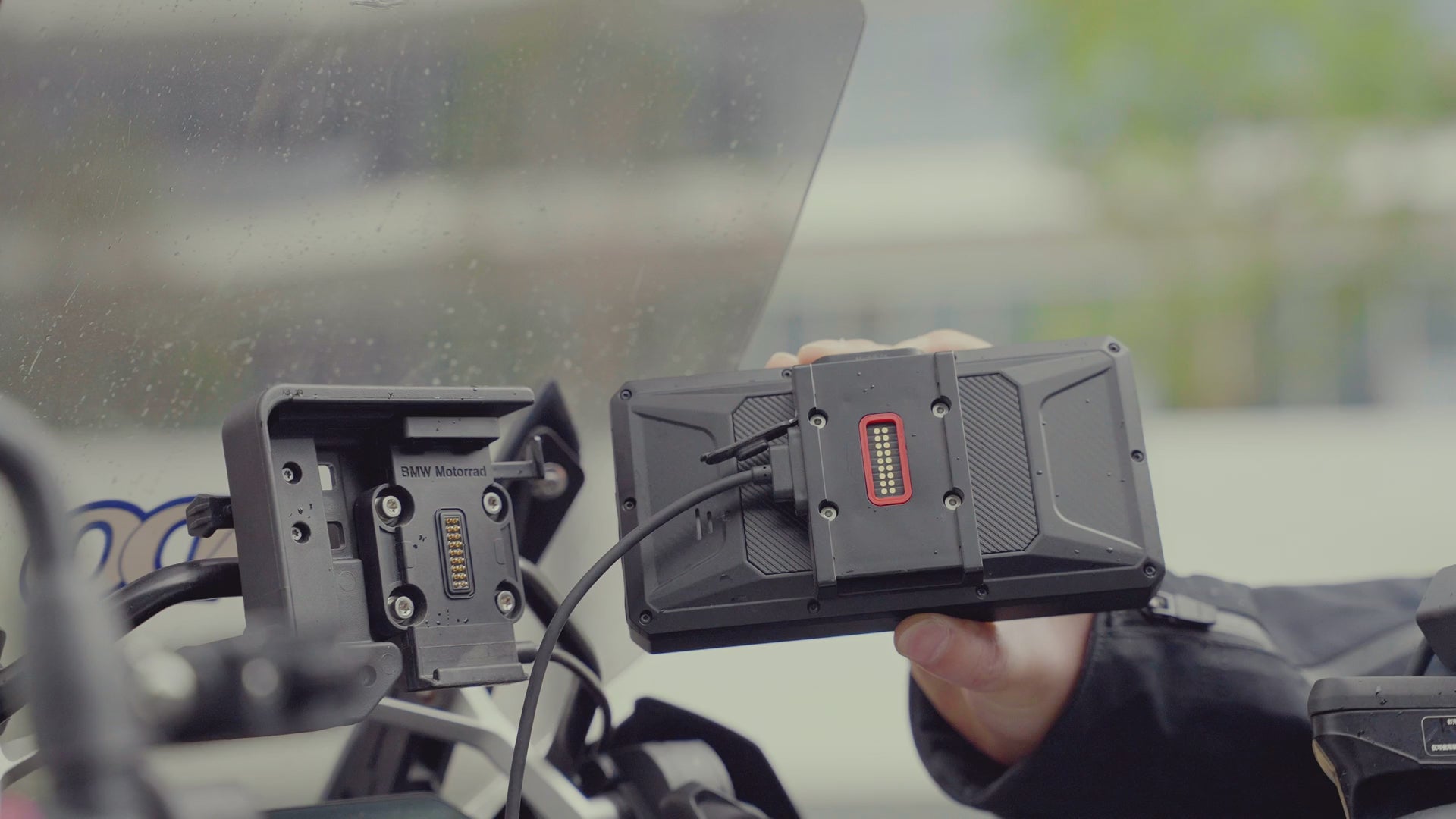 Télécharger une vidéo : Support BMW à dégagement rapide, utilisable d&#39;une seule main : accrochez-le, sentez le « clic » et le levier de sécurité bloque le tout de manière stable. Double système de fixation pour résister aux vibrations et aux chemins de terre. Alimentation intégrée, aucun câble apparent. Retrait immédiat pour fonction antivol.